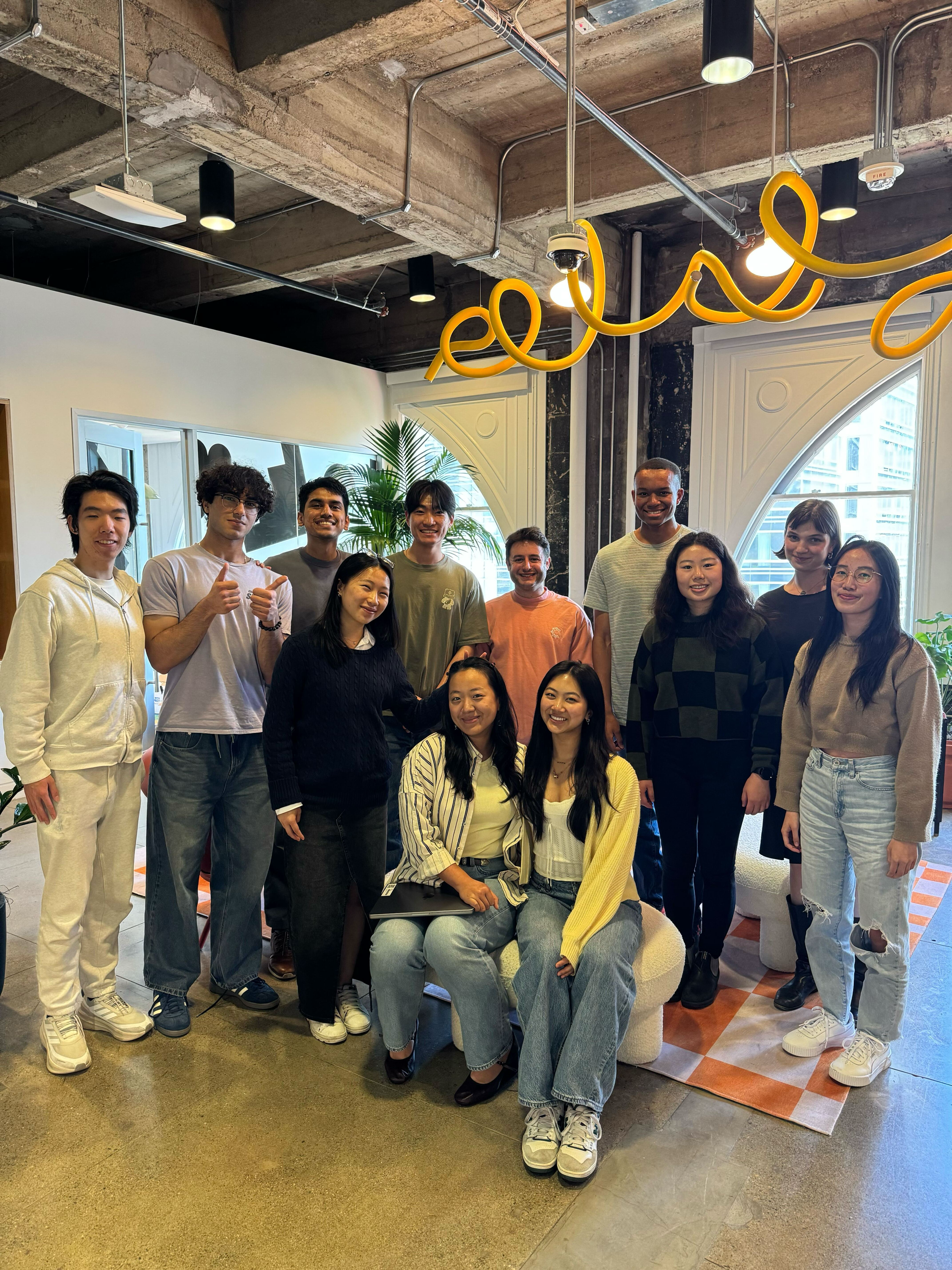 Figma interns and CEO Dylan Field posing together in the office.