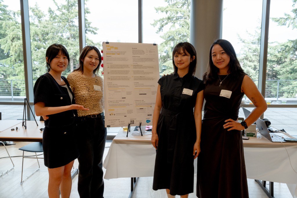 Team photo at the capstone showcase beside the mmmm poster.