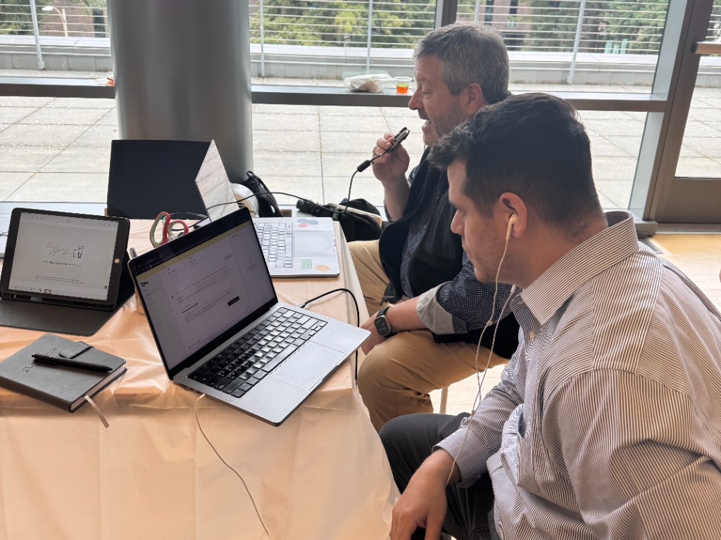 Judges reviewing the mmmm prototype setup on laptops at the showcase table.